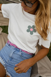 T-shirt à motif floral porté par une femme, vue rapprochée, fleur grise, short en jean