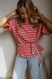 T-shirt à strass avec foulard porté par une femme, vue rapprochée, mains dans les cheveux, jean clair