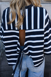 T-shirt rayé à dos ouvert porté par une femme, gros plan du dos ouvert et du nœud