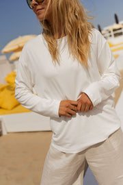 T-shirt doux à manches longues blanc porté par une femme, vue rapprochée, lunettes de soleil, manches longues