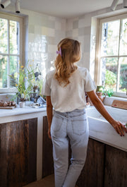 T-shirt épais à boutons d’épaule porté par une femme, vue de dos, cuisine, cheveux attachés