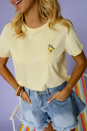 T-shirt à logo citron porté par une femme, vue rapprochée, mains dans les poches