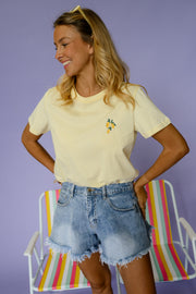 T-shirt à logo citron porté par une femme, silhouette entière, mains sur les hanches