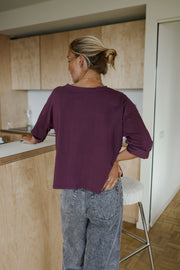 T-shirt à manches trois-quarts porté par une femme, vue de dos, près d'un comptoir