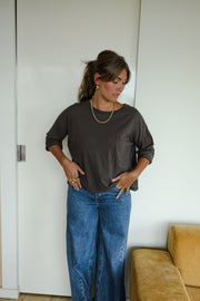 T-shirt ample à poche poitrine porté par une femme, silhouette entière, mains dans les poches