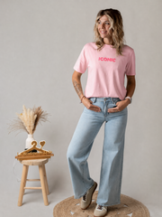 T-shirt en coton extensible porté par une femme, silhouette entière, jean large, tabouret