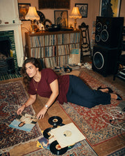 T-shirt en coton à nouer porté par une femme, assise, tapis, vinyles