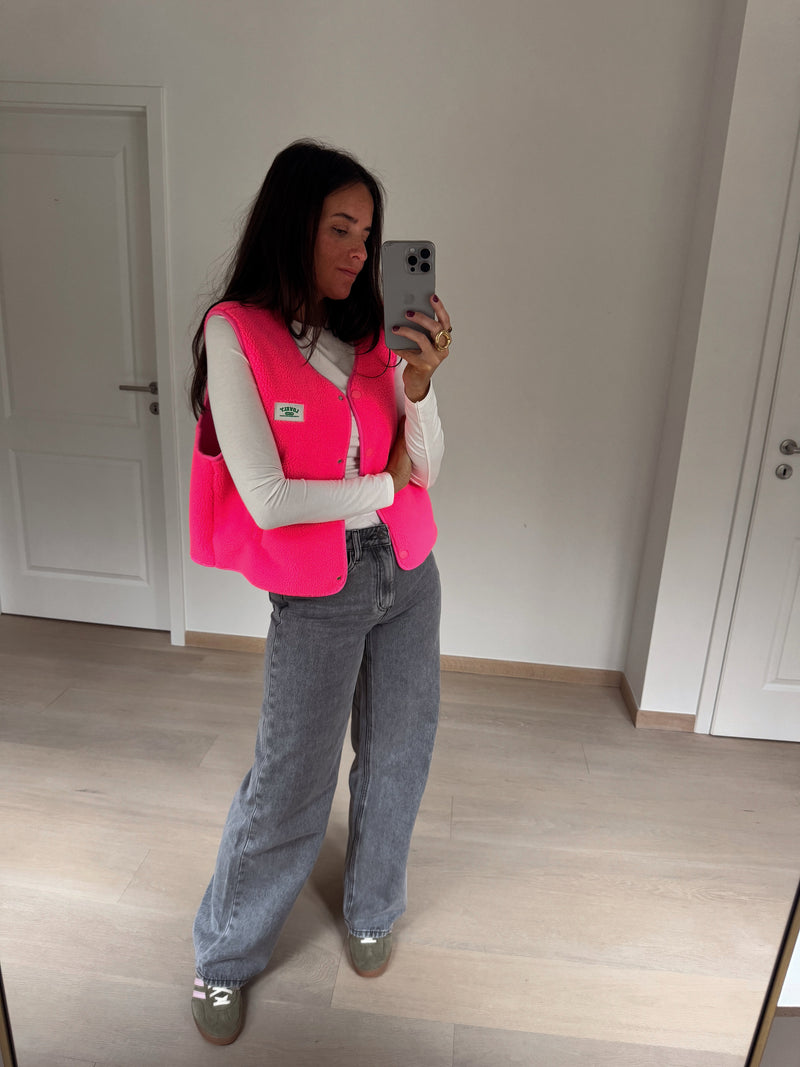 Gilet mouton sans manches rose porté par une femme, vue de face, selfie au miroir, jean gris