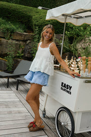 Top dentelle à col carré porté par une femme, silhouette entière, short en jean, chariot à glaces