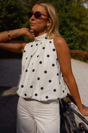 Top à pois effet ballon porté par une femme, vue rapprochée, lunettes, pois