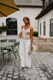 Top à fines bretelles ajustables porté par une femme, silhouette entière, terrasse, sac