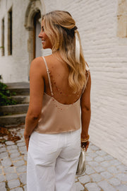 Top à fines bretelles ajustables porté par une femme, vue de dos, pantalon blanc, sac