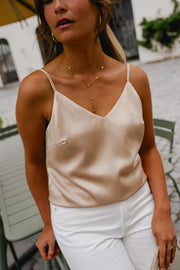 Top à fines bretelles ajustables porté par une femme, vue rapprochée, bretelles ajustables, pantalon blanc