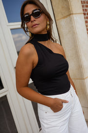 Top asymétrique moulant à nouer porté par une femme, vue rapprochée, épaule asymétrique, lunettes