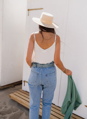 Top à décolleté brodé porté par une femme, vue de dos, chapeau, jean
