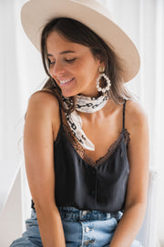 Top doublé à bretelles réglables porté par une femme, vue rapprochée, foulard, boucles d'oreilles, chapeau