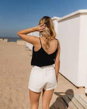 Top doublé à bretelles réglables porté par une femme, vue de dos, plage, short blanc