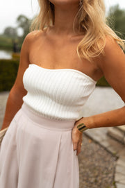 Top bustier effet maille porté par une femme, vue rapprochée, bustier blanc, jupe rose