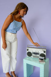 Top vichy perlé à nouer porté par une femme, vue de trois-quarts, radio, pantalon blanc