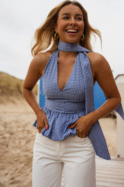Top vichy dos ouvert porté par une femme, vue rapprochée, foulard au cou, pantalon blanc
