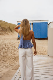 Top vichy dos ouvert porté par une femme, vue de dos, pantalon blanc, plage