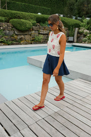 Top crochet à homards brodés porté par une femme, silhouette entière, jupe bleu marine, ponton