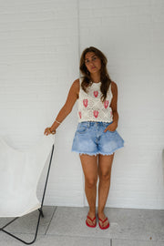 Top crochet à homards brodés porté par une femme, silhouette entière, short en jean, mur blanc