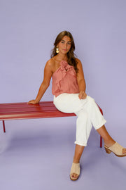 Top volanté à nouer porté par une femme, assise, banc rouge, pantalon blanc