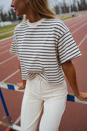 T-shirt court rayé porté par une femme, vue rapprochée, rayures, mains sur les hanches