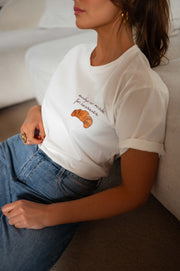 T-shirt à logo croissant blanc porté par une femme, vue rapprochée, jean bleu, croissant brodé