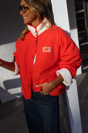 Veste réversible doublée mouton corail portée par une femme, vue de trois-quarts, côté rouge, col sherpa