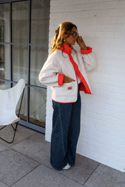 Veste réversible doublée mouton corail portée par une femme, vue de face, côté sherpa, foulard rouge