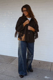 Veste à franges col revers portée par une femme, vue de face, franges, bras le long du corps