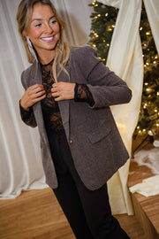 Blazer à carreaux effet tweed porté par une femme, vue rapprochée, blazer gris, sourire
