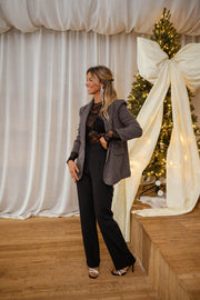 Blazer à carreaux effet tweed porté par une femme, vue de face, ruban blanc, pantalon noir