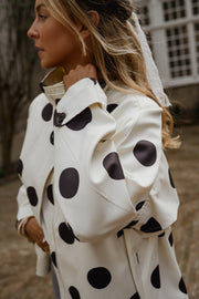 Veste souple à pois portée par une femme, vue rapprochée, foulard dans les cheveux, de profil