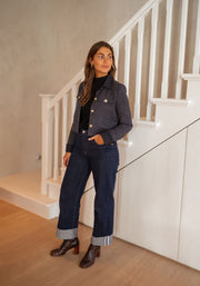 Veste en tweed à poches bleue portée par une femme, vue de face, escalier, jean foncé