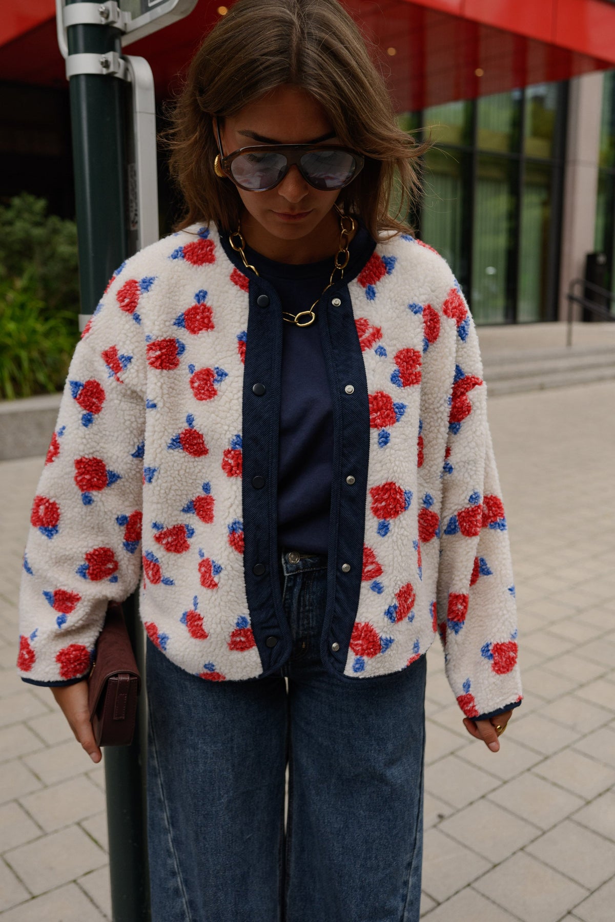 Veste imprimée à boutons-pression portée par une femme, vue rapprochée, lunettes de soleil