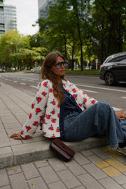 Veste imprimée à boutons-pression portée par une femme, assise, sur le trottoir