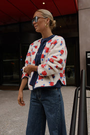 Veste imprimée à boutons-pression portée par une femme, vue de face, lunettes de soleil