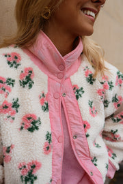 Veste polaire réversible fleurie portée par une femme, vue rapprochée, roses, foulard rose