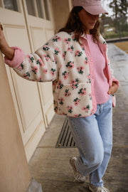 Veste polaire réversible fleurie portée par une femme, vue de dos, casquette rose, volets