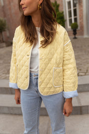 Veste matelassée à doublure rayée portée par une femme, vue rapprochée, col rond, jean