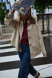 Veste souple à revers velours beige portée par une femme, vue de face, passage piéton, pochette sur la tête
