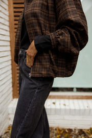Veste à carreaux à poches portée par une femme, vue rapprochée, carreaux marron, manche