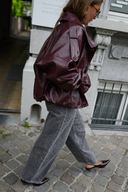 Veste en simili cuir loose portée par une femme, en marchant, de profil