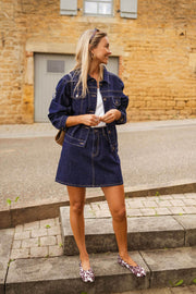 Veste en jean courte portée par une femme, vue de face, marches, sac en toile