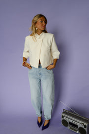 Veste courte à manches courtes portée par une femme, silhouette entière, jean clair, talons