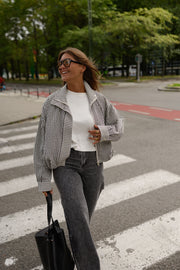 Veste courte déperlante vichy gris et blanc portée par une femme, silhouette entière, sac noir