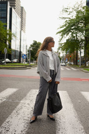 Veste courte déperlante vichy gris et blanc portée par une femme, en marchant, passage piéton